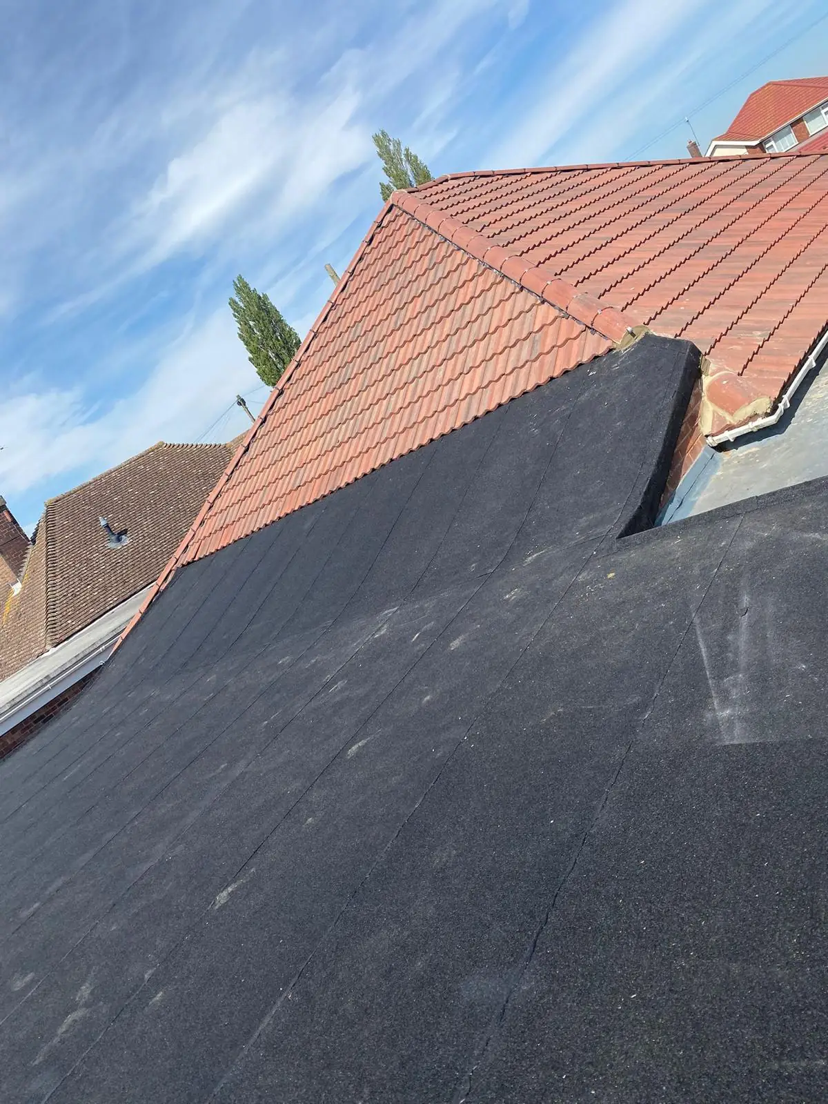 A flat roof finished alongside a red pantile gable
