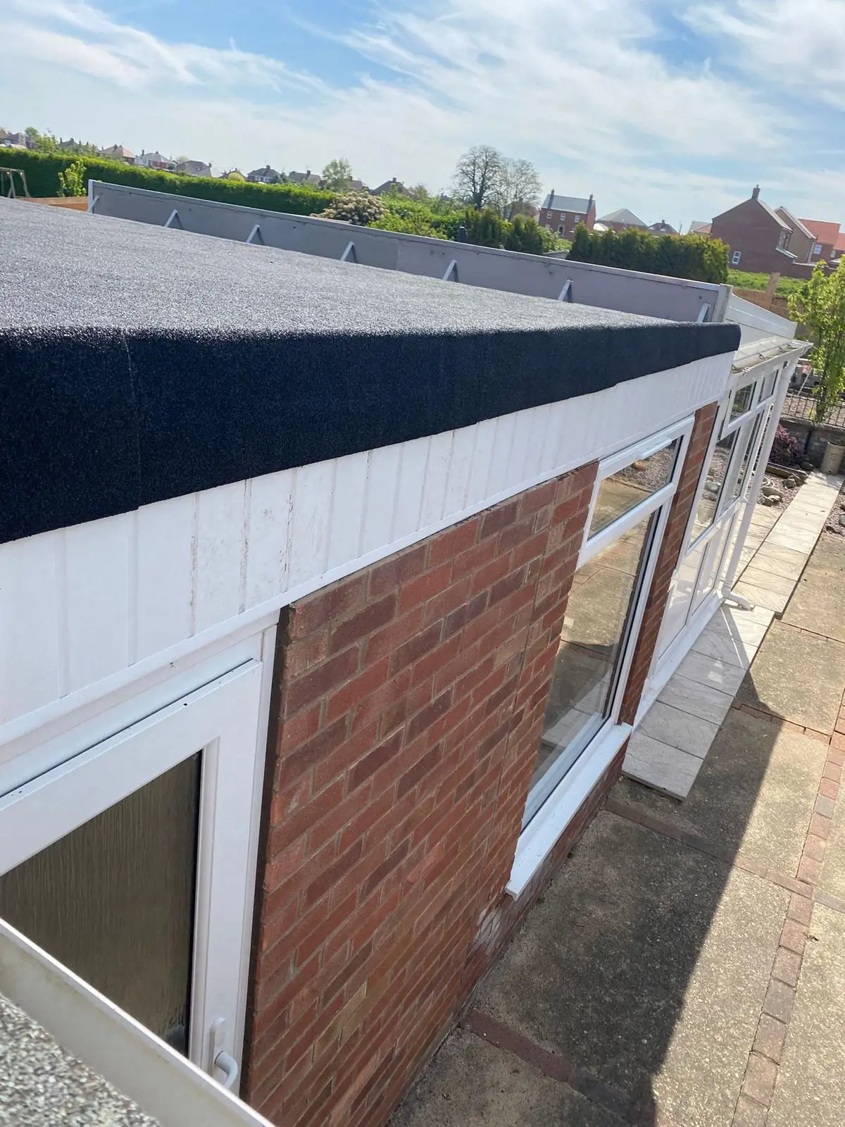 A new flat roof on a rear extension, with white fascia and guttering