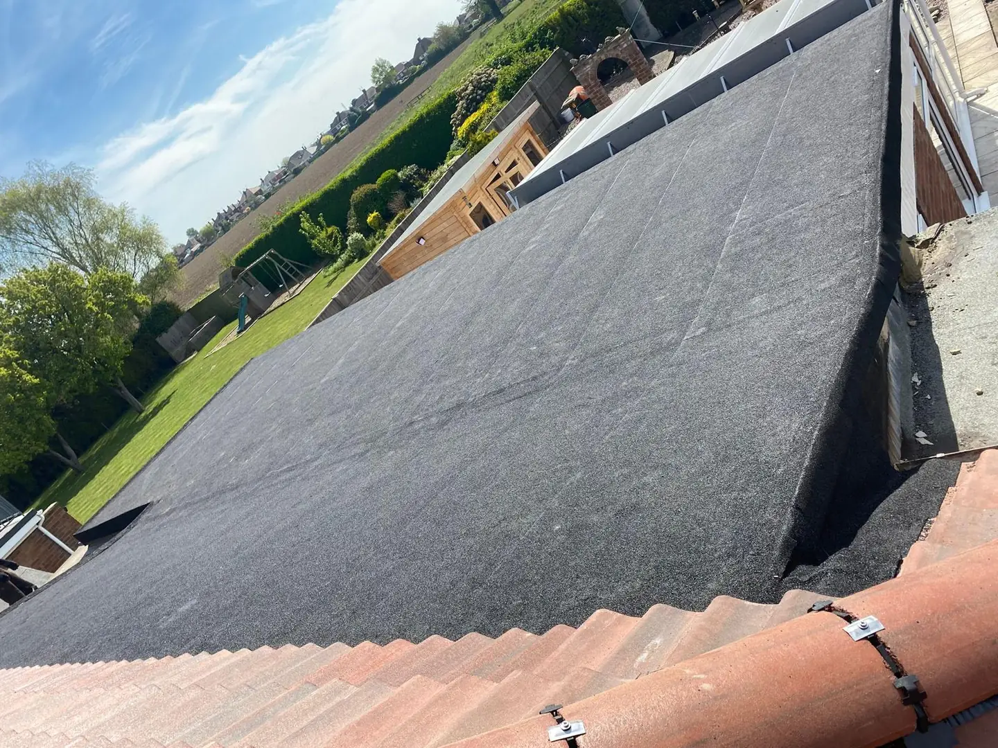 A large flat roof completed above a rear extension, garden beyond
