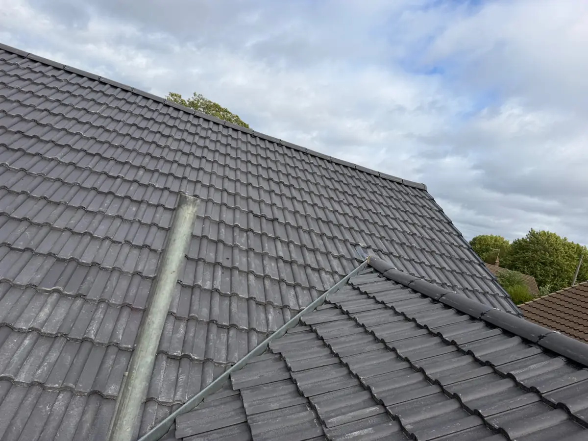 A valley where two newly tiled roof slopes meet, with ridge tiles fitted above