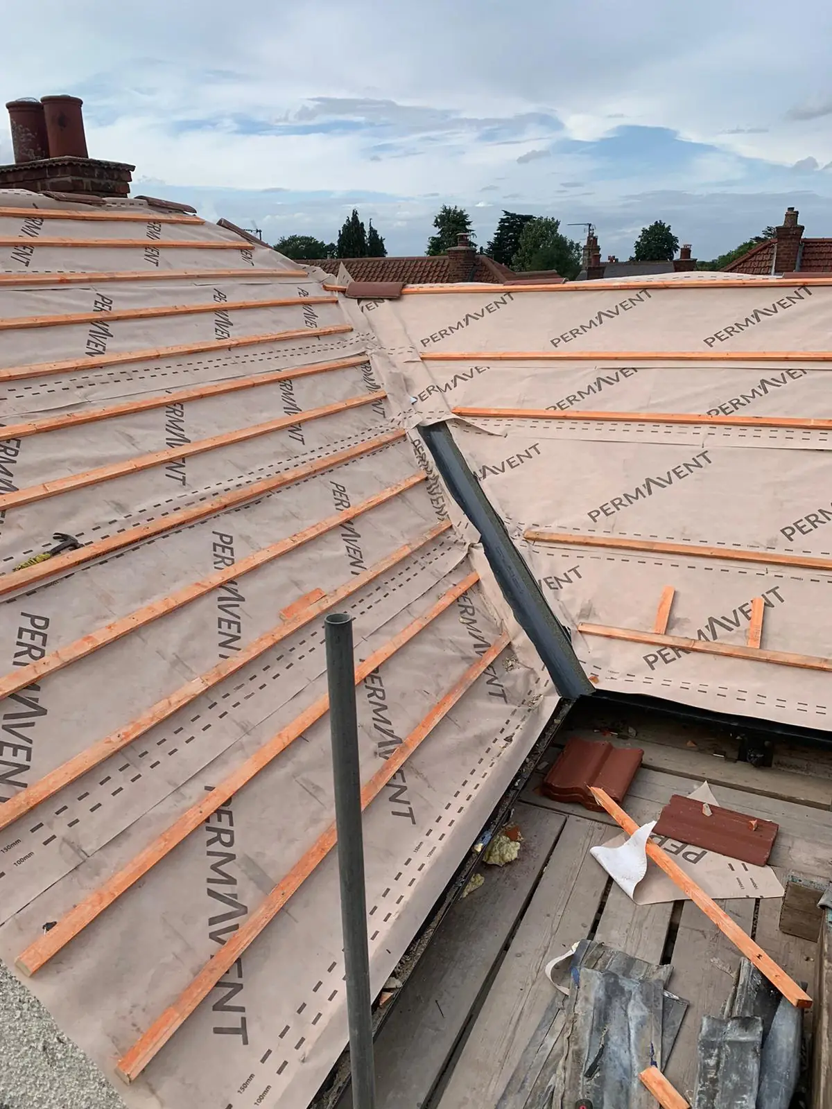Breathable membrane and new red tiles going on at the hip during a re-roof