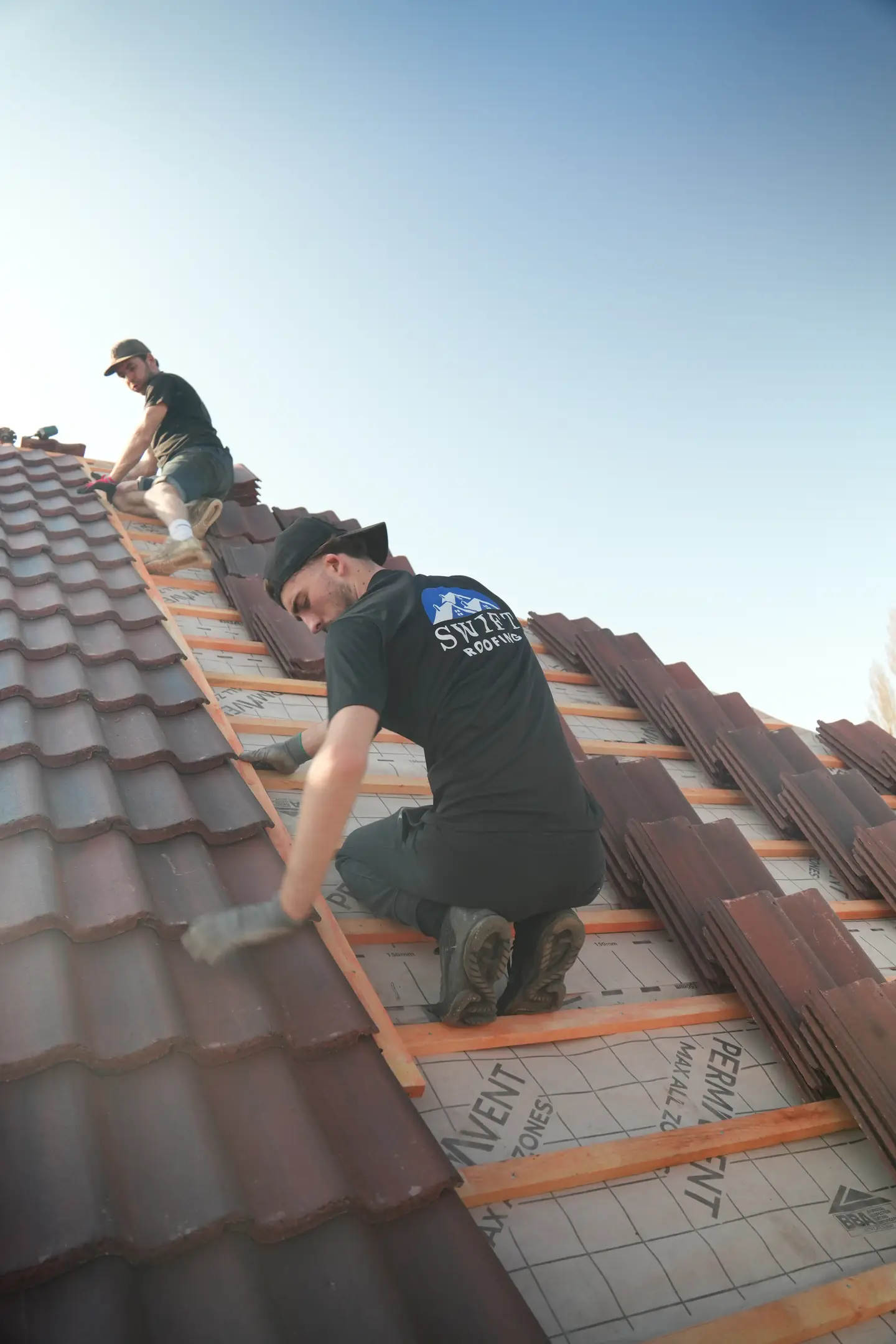 A Swift Roofing roofer fixing a tile to the batten during a re-roof