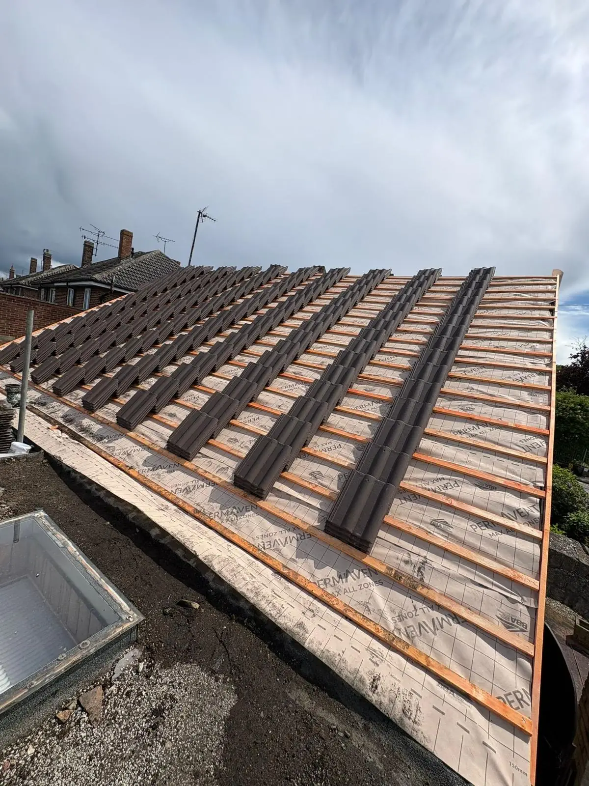 A roof stripped back to battens and breathable membrane part way through a full re-roof