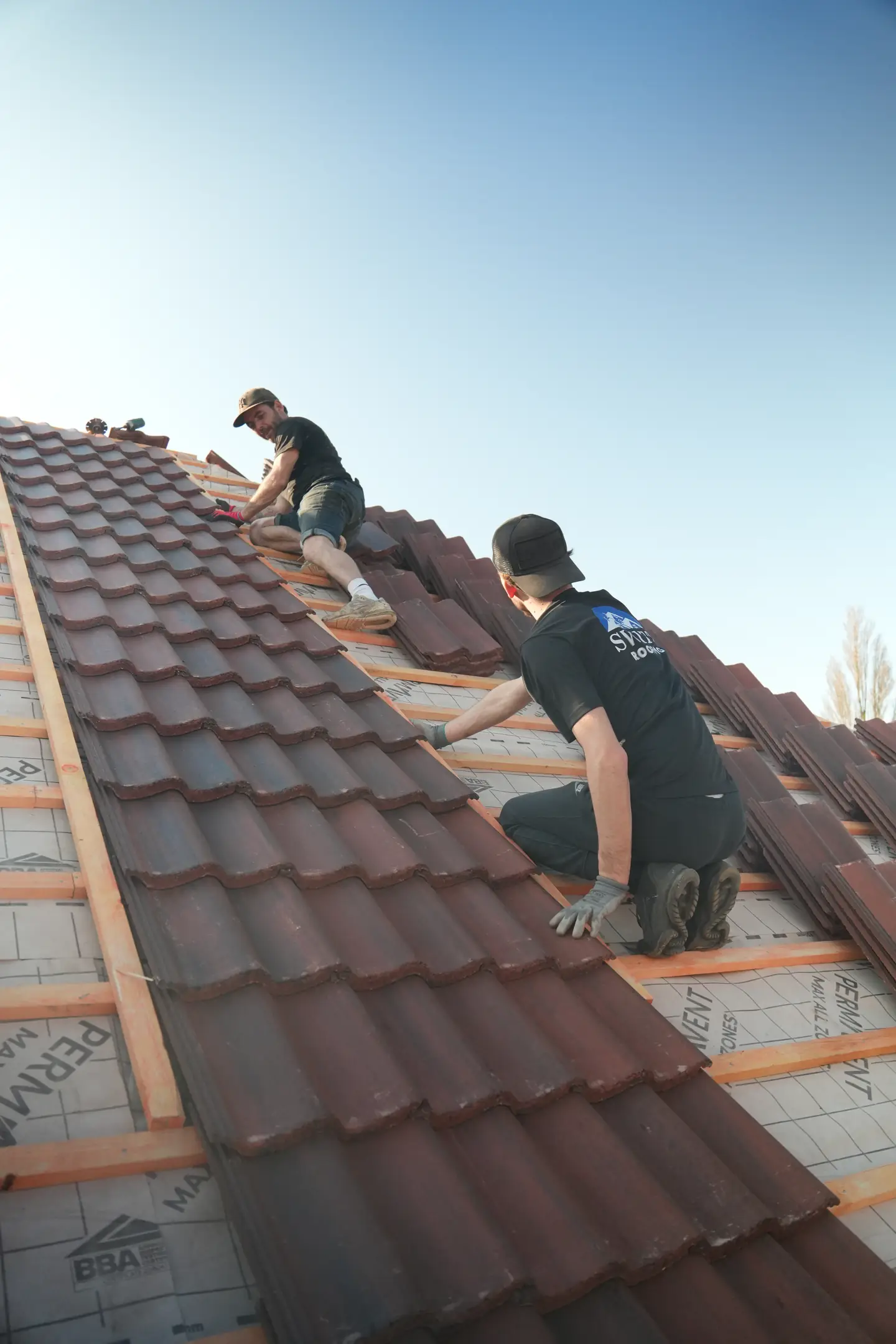 Two Swift Roofing roofers tiling over fresh battens and breathable membrane
