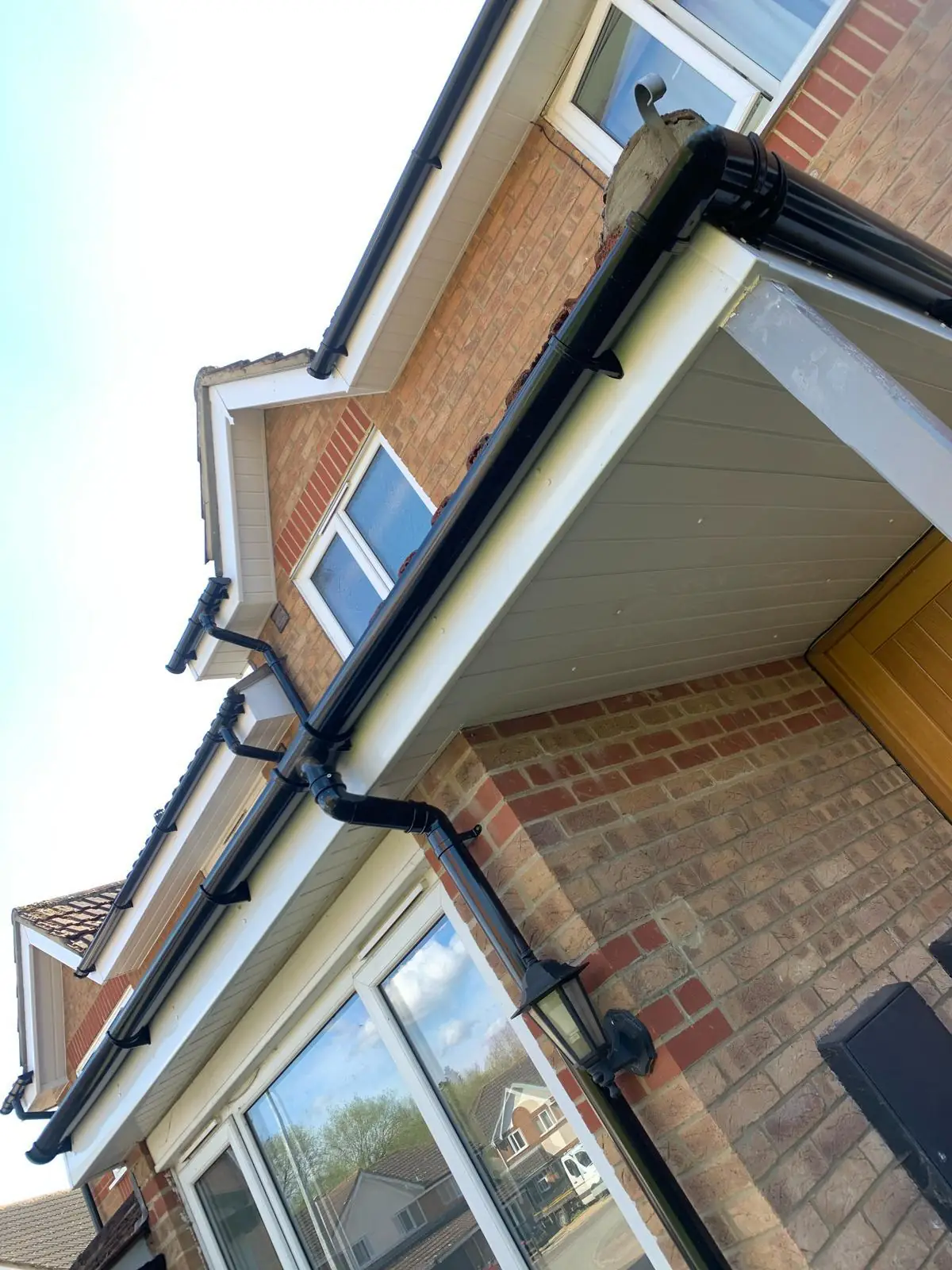 New black guttering, white soffit and downpipe on a brick house