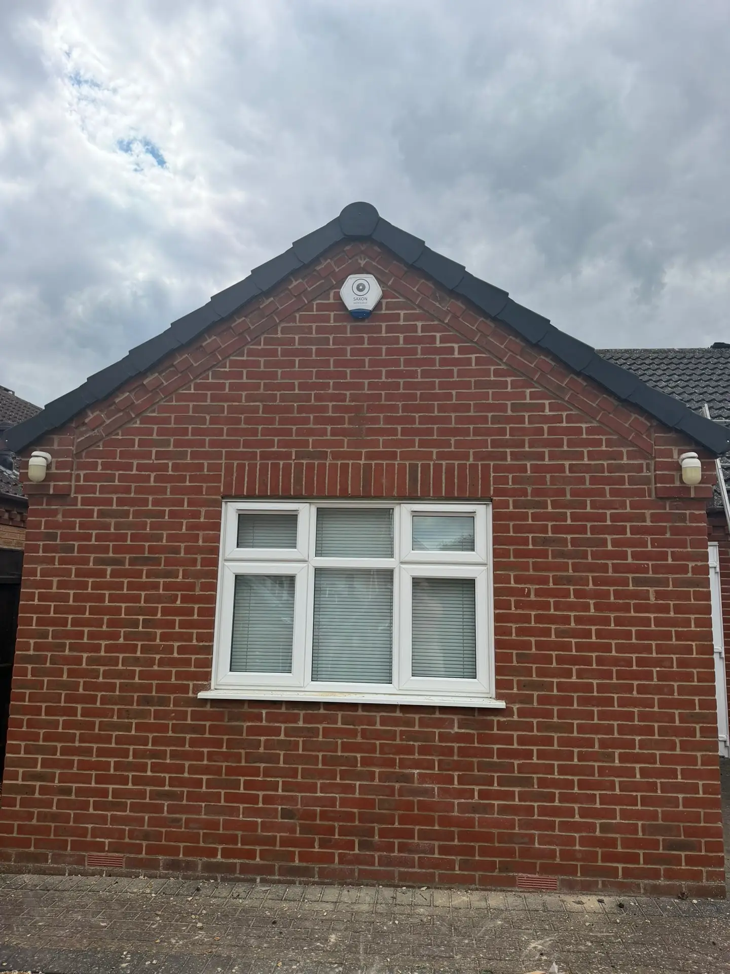 A red brick gable end with a new dark dry verge and roofline