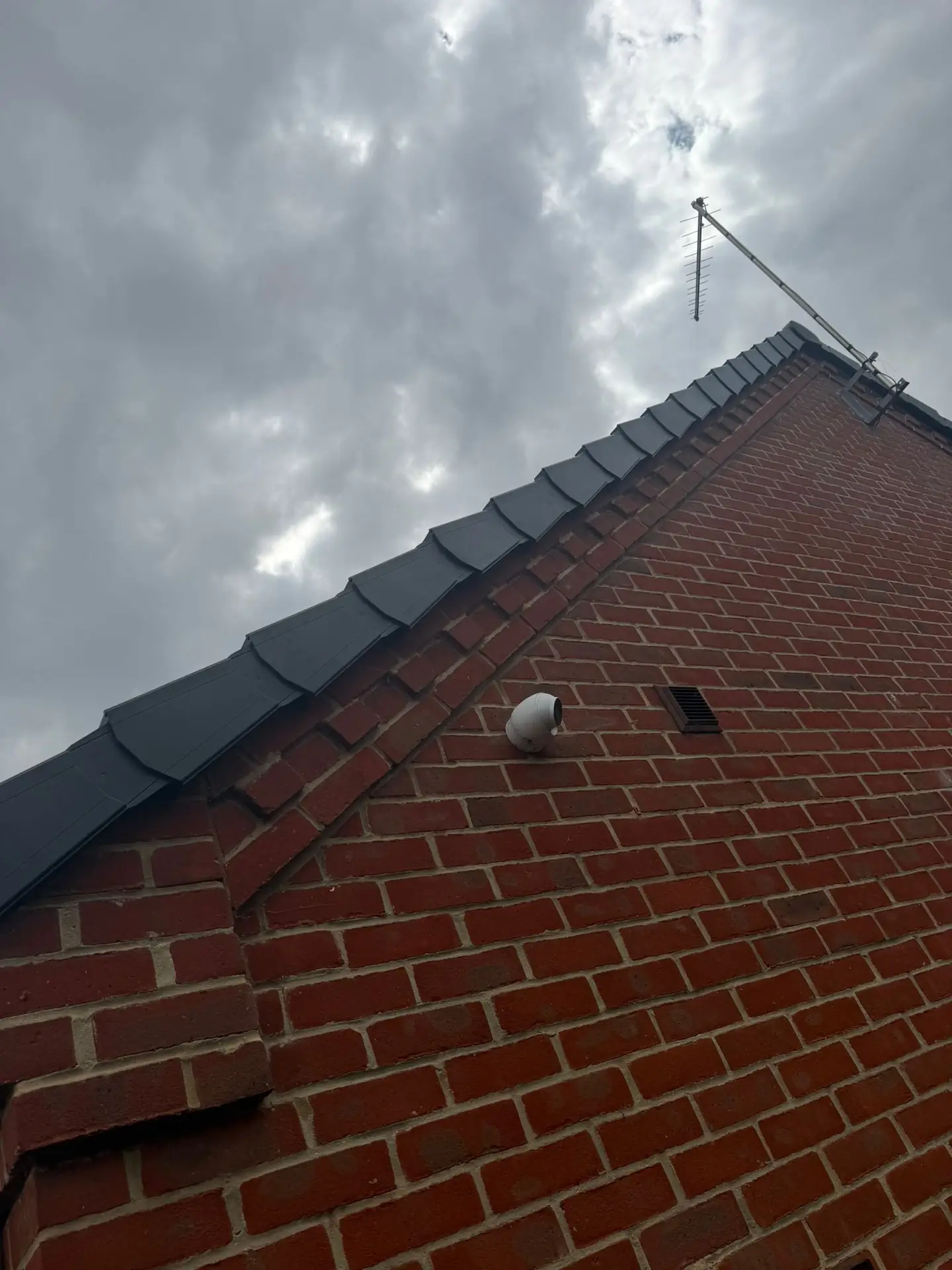 A finished dark roofline and new bargeboards on a red brick gable