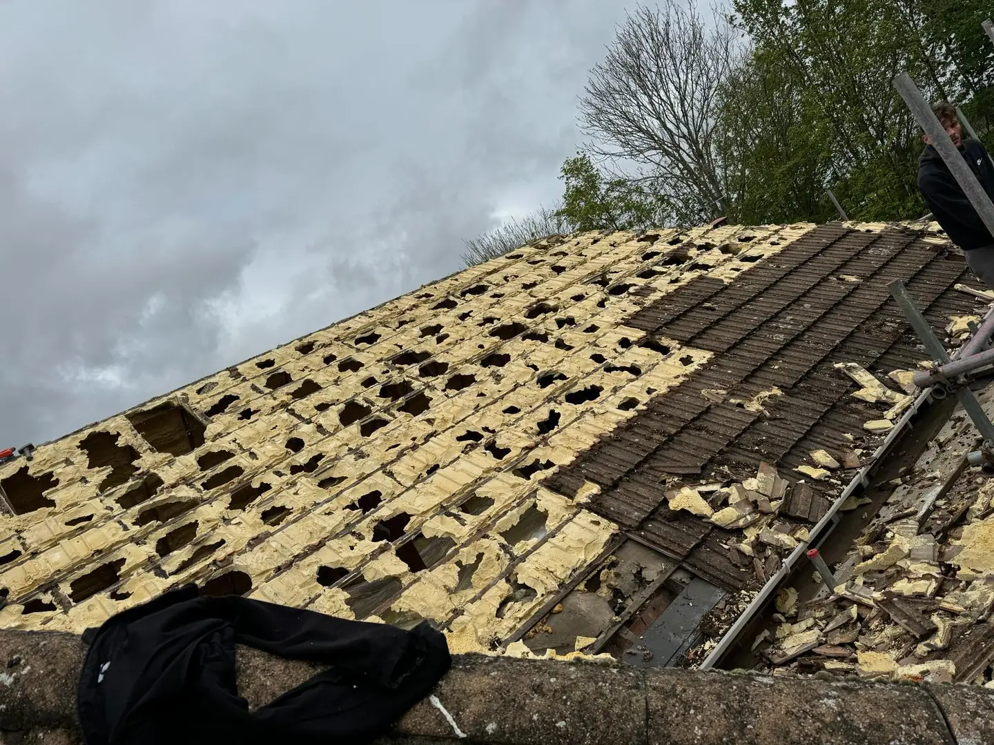 Roof tiles with spray foam insulation bonded to the underside, exposed during removal