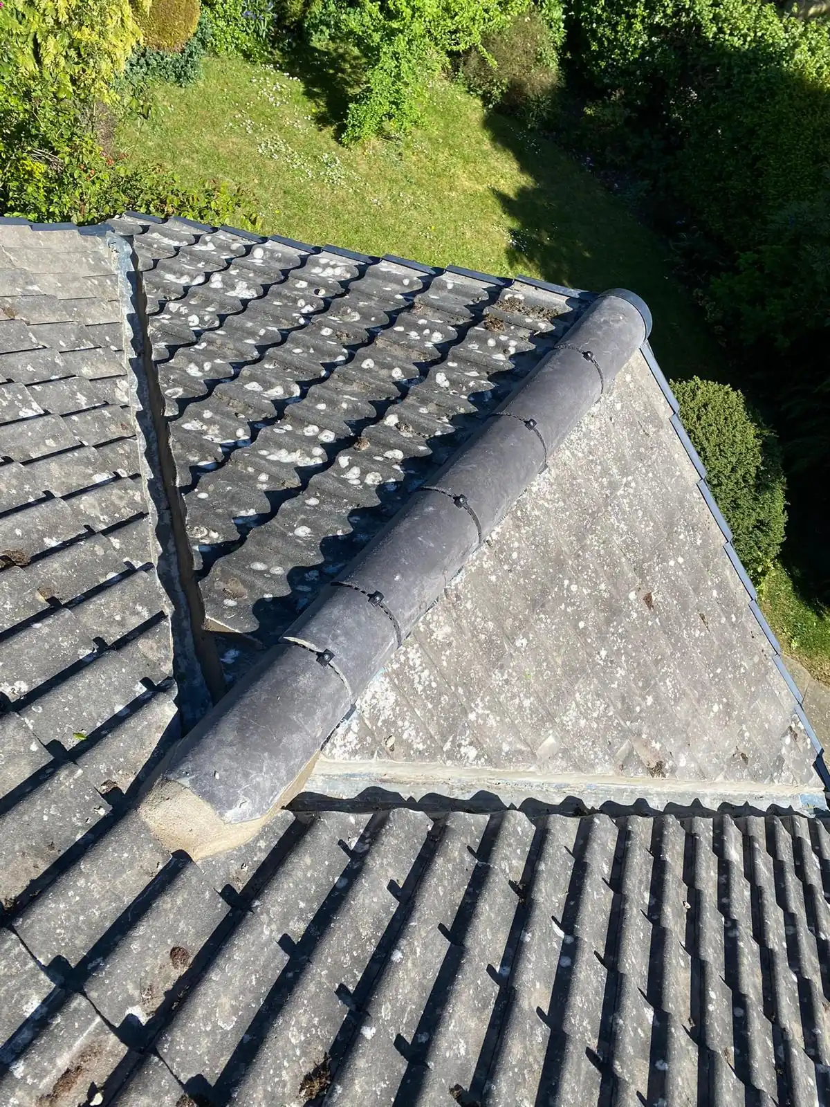 A dark grey tiled roof with new ridge and hip tiles completed